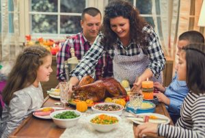 mother serving freshly baked stuffed turkey for Thanksgiving